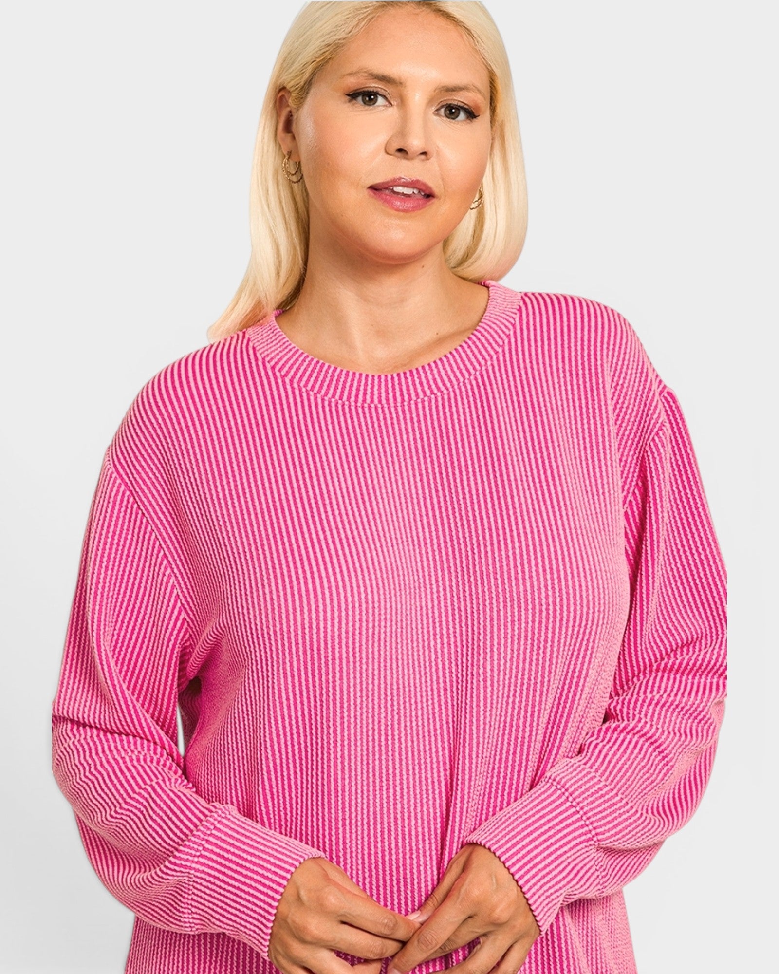 Woman wearing a pink ribbed sweater on a white background