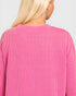 Close-up of a person wearing a pink and white striped sweater on a light gray background