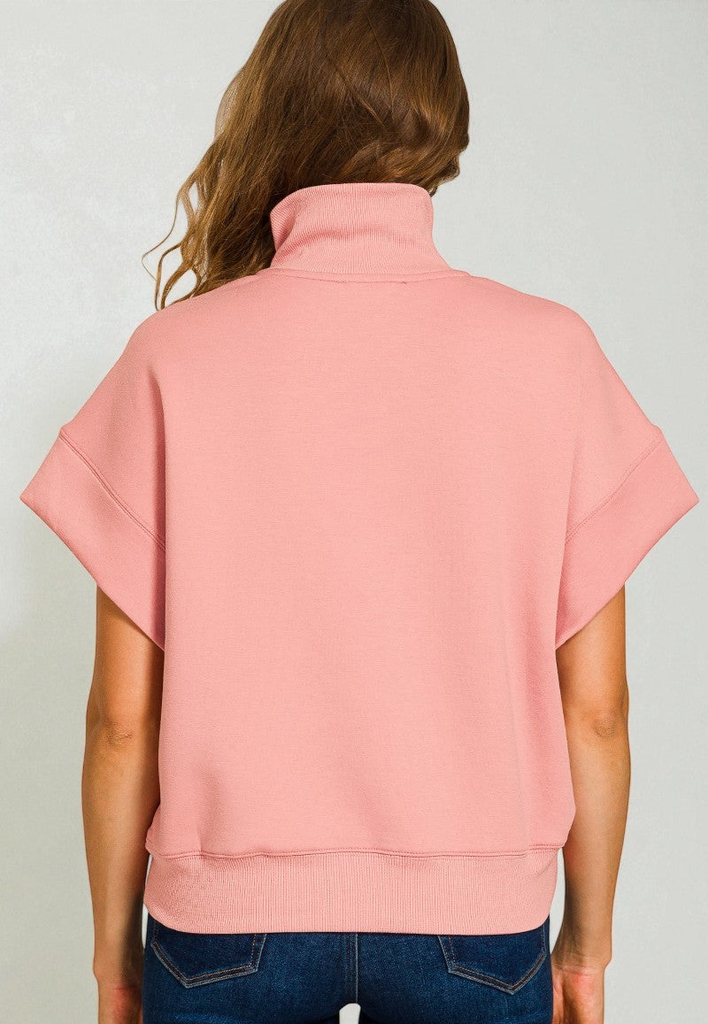 Person wearing a pink sleeveless top against a plain background