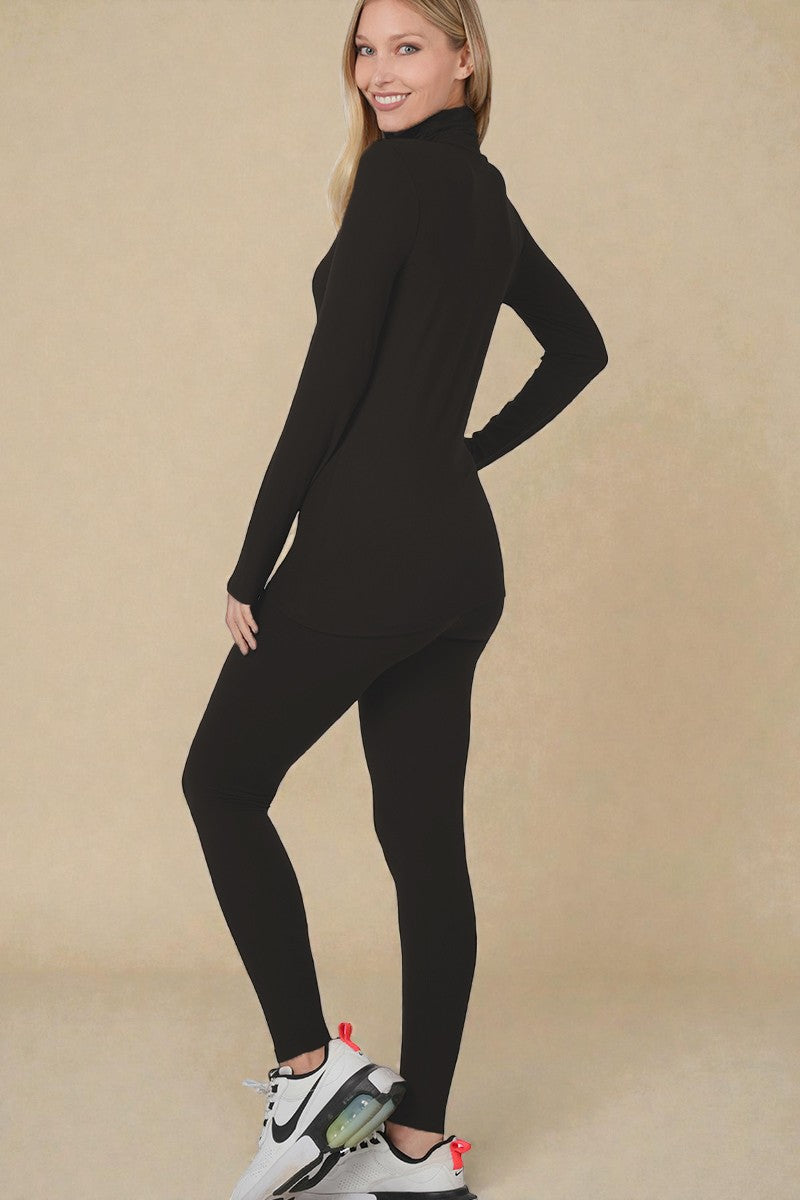 Woman wearing a black long-sleeve top and leggings on a beige background