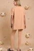 Woman wearing a peach-colored outfit against a beige background with decorative elements.