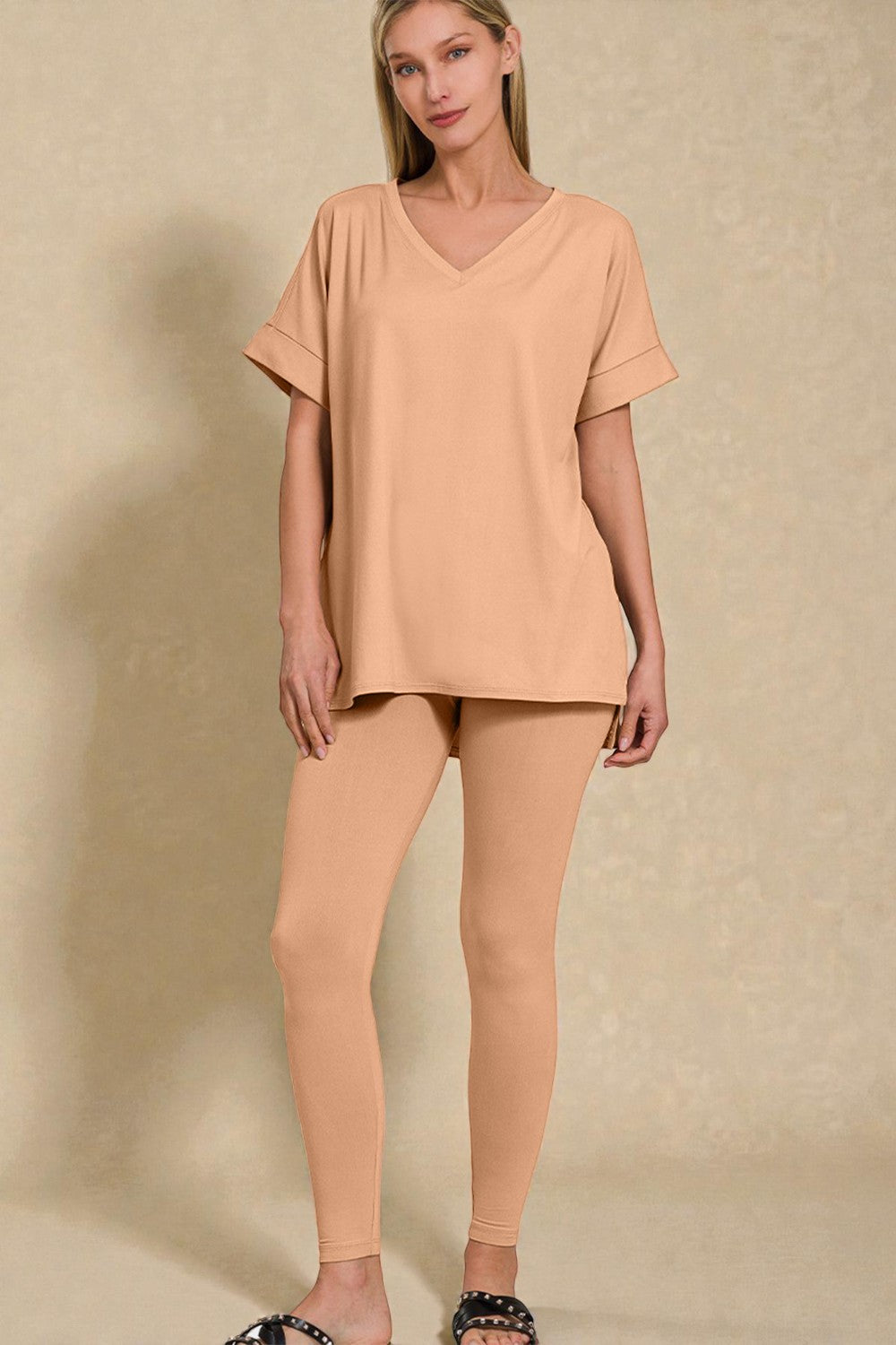 Woman wearing a peach-colored outfit against a beige background