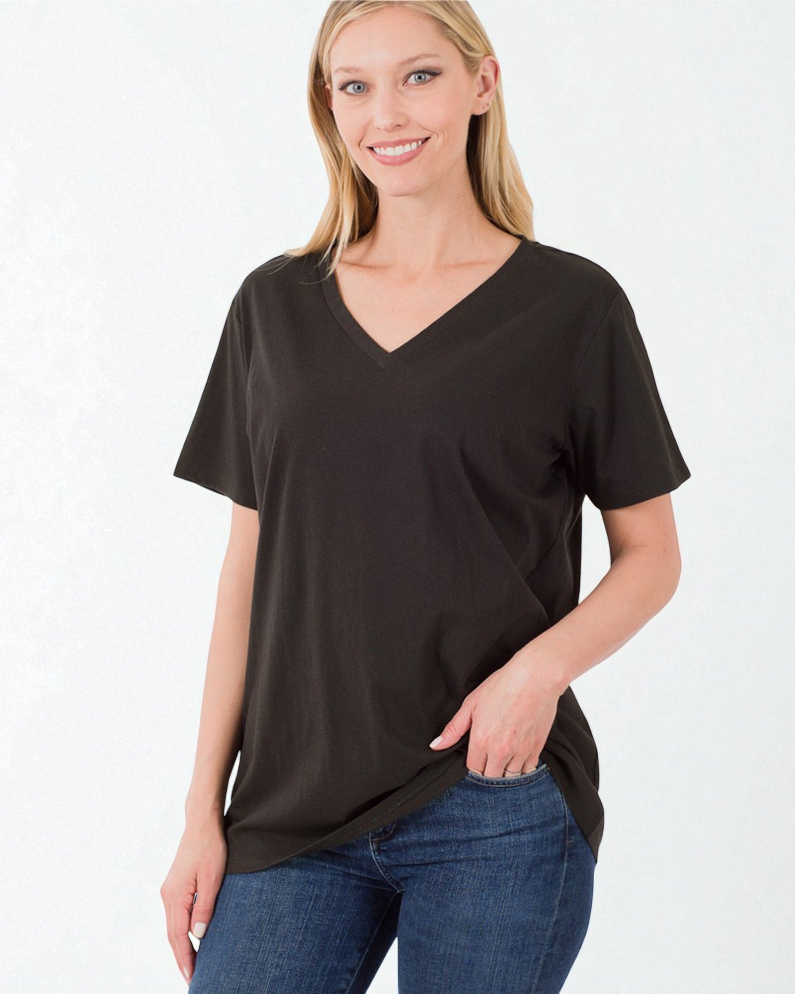 Woman wearing a black V-neck t-shirt and blue jeans on a white background