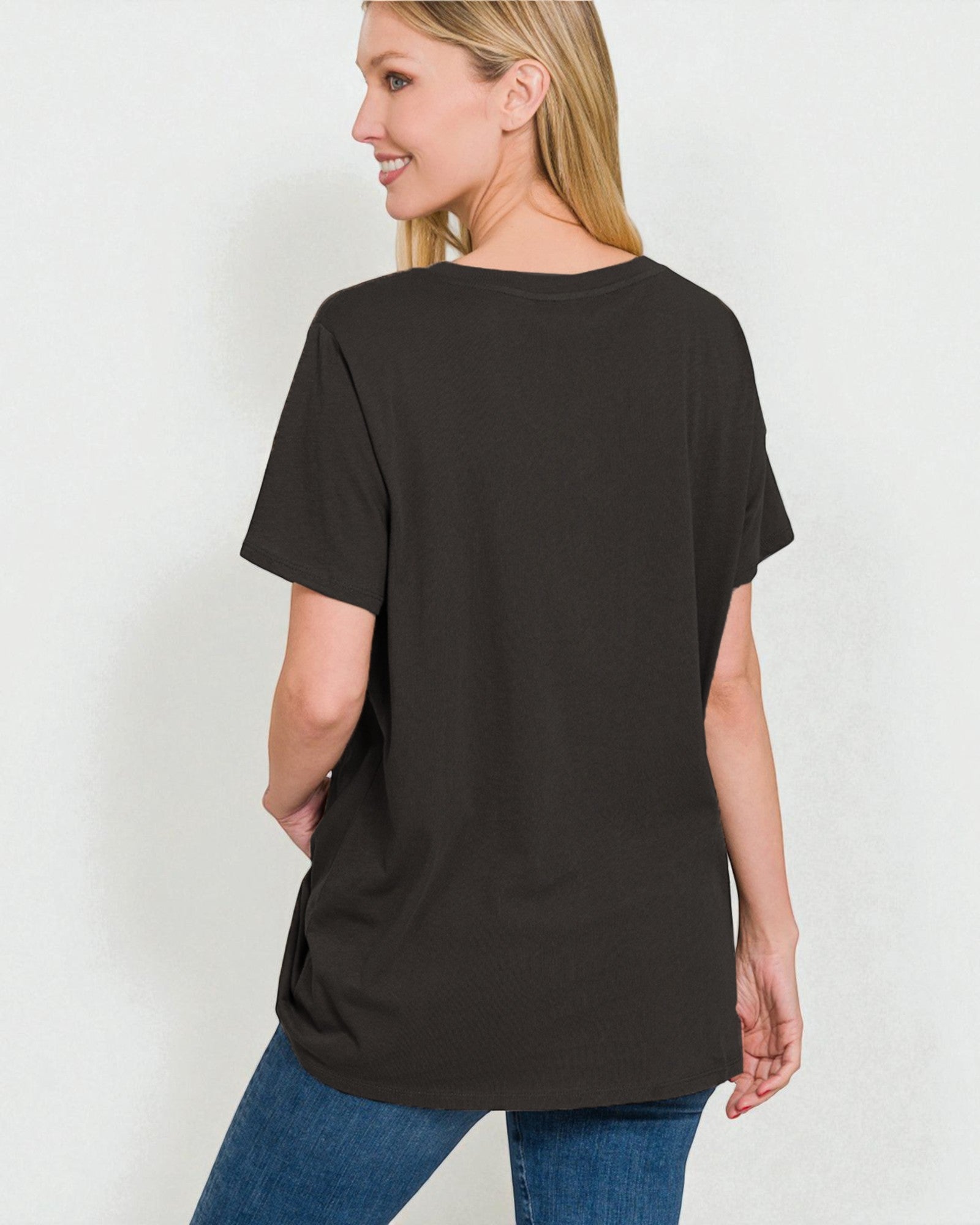 Woman wearing a black t-shirt and blue jeans on a white background