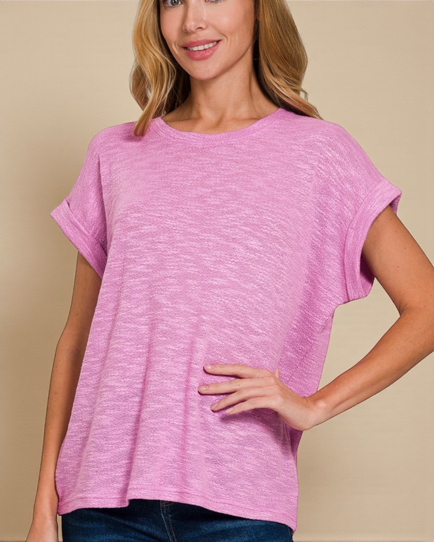 Woman wearing a pink t-shirt against a beige background