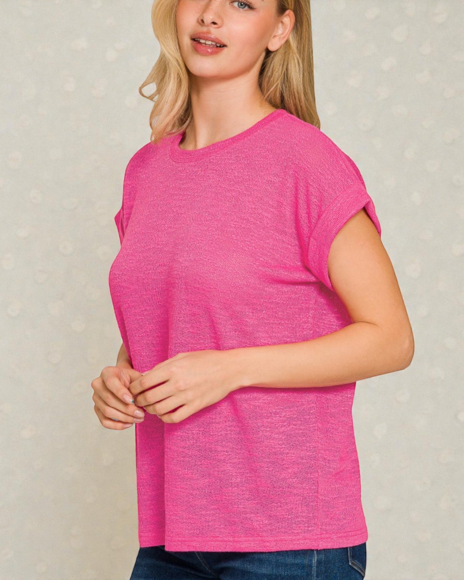 Woman wearing a pink t-shirt against a neutral background