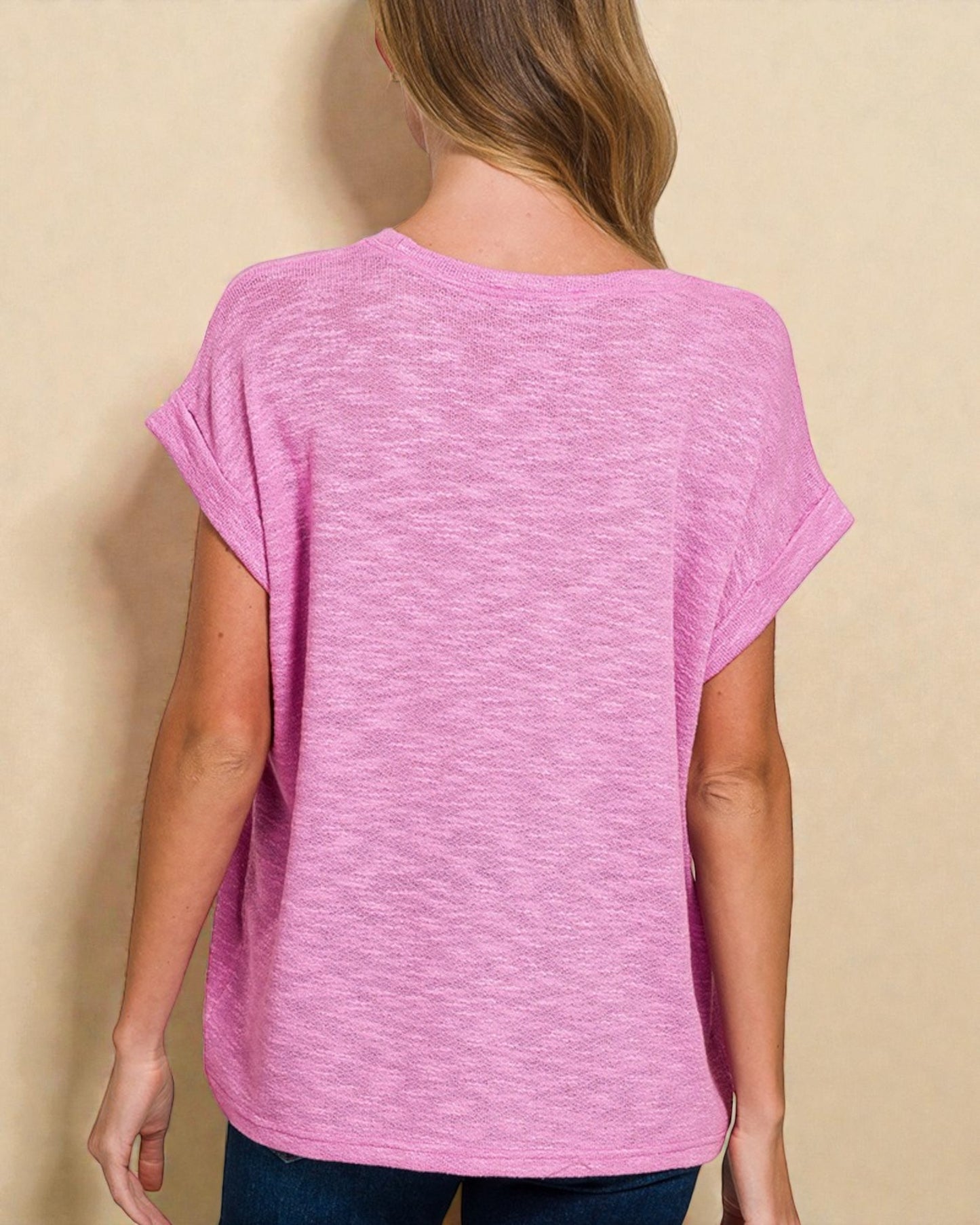 Person wearing a pink t-shirt against a beige background