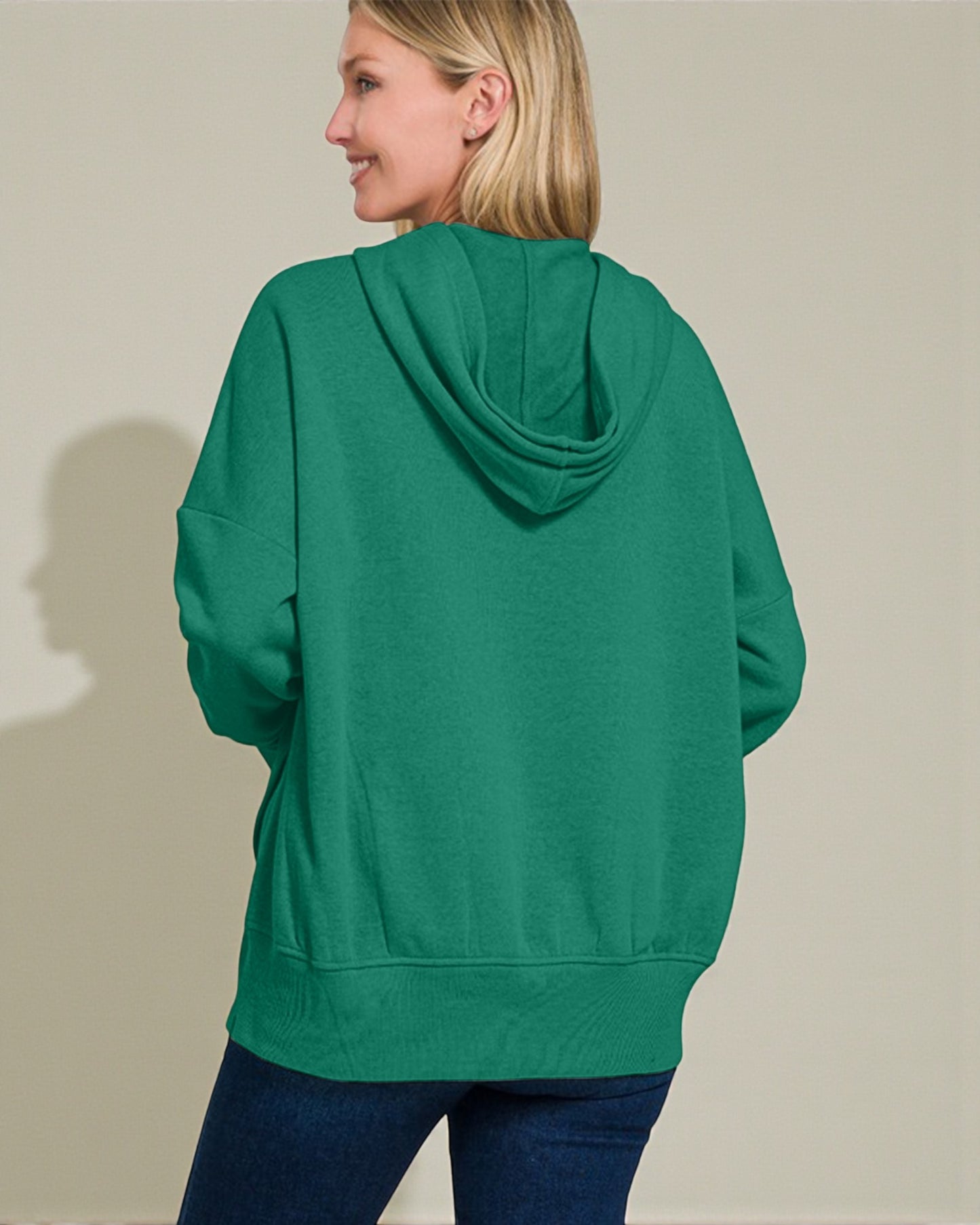 Person wearing a green hoodie from behind on a plain background