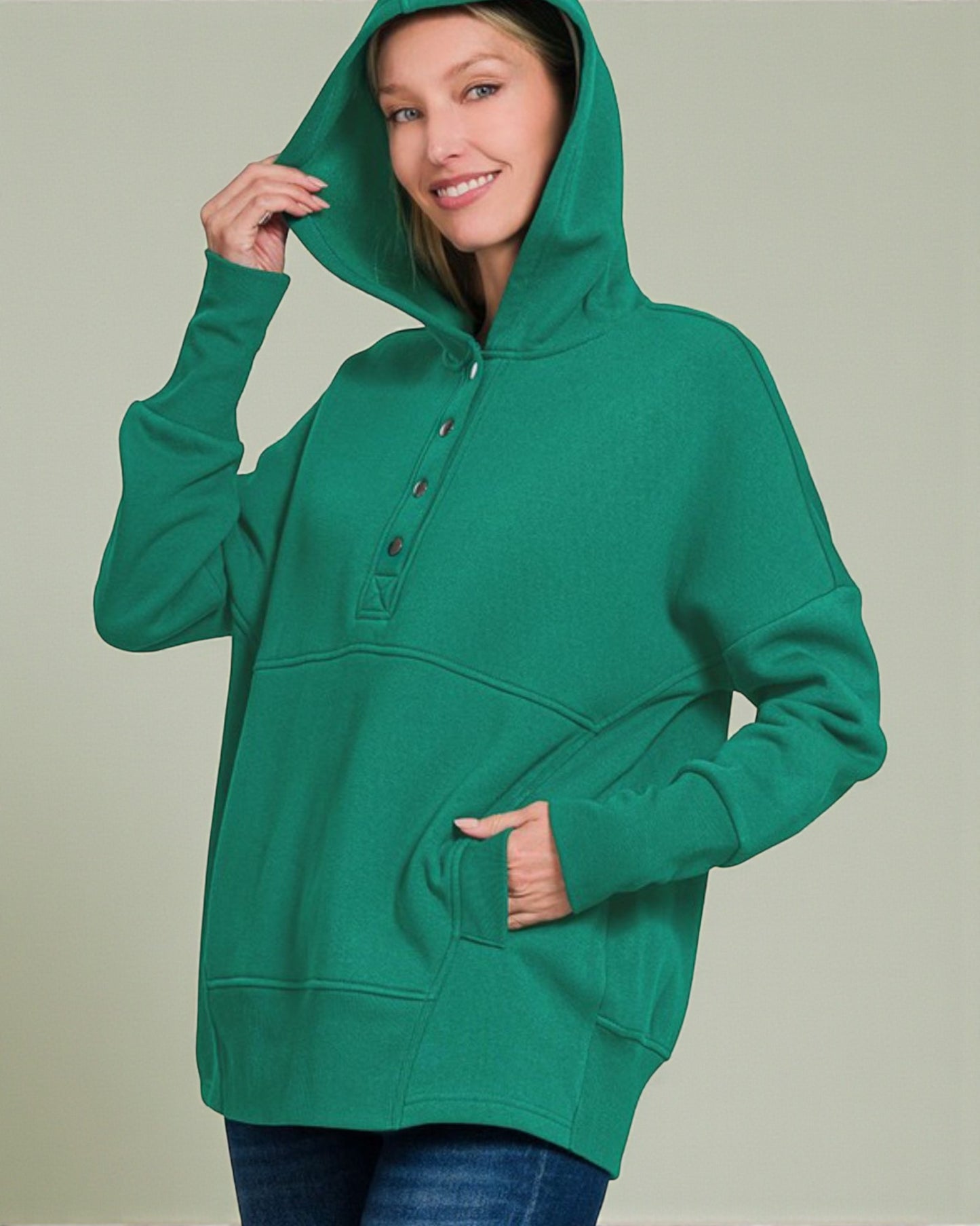 Person wearing a green hoodie against a plain background