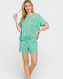 Woman wearing a green pajama set on a white background