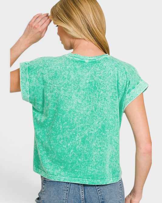 Woman wearing a green t-shirt and blue jeans on a white background