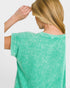 Person wearing a green t-shirt with a plain background