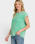 Woman wearing a green t-shirt and blue jeans on a white background
