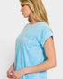 Woman wearing a light blue t-shirt against a white background
