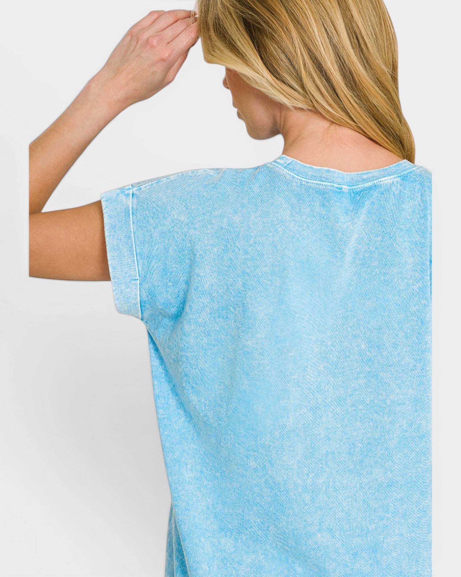 Woman wearing a light blue t-shirt against a plain background