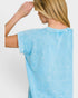 Woman wearing a light blue t-shirt against a plain background