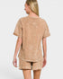 Woman wearing a beige t-shirt and shorts set on a white background