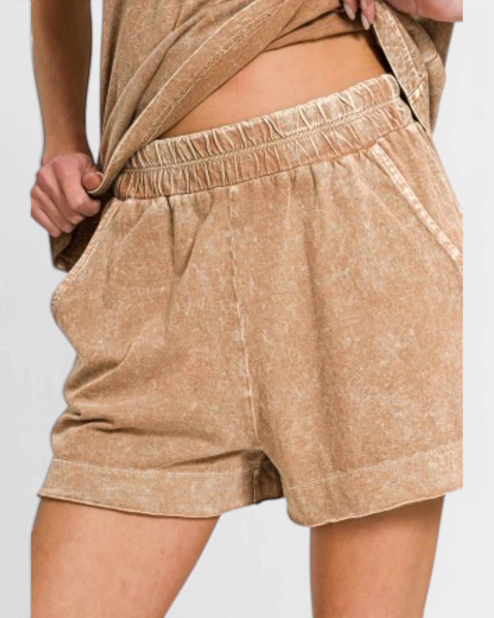 Beige shorts worn by a person on a light gray background