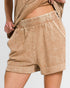 Beige shorts worn by a person on a light gray background
