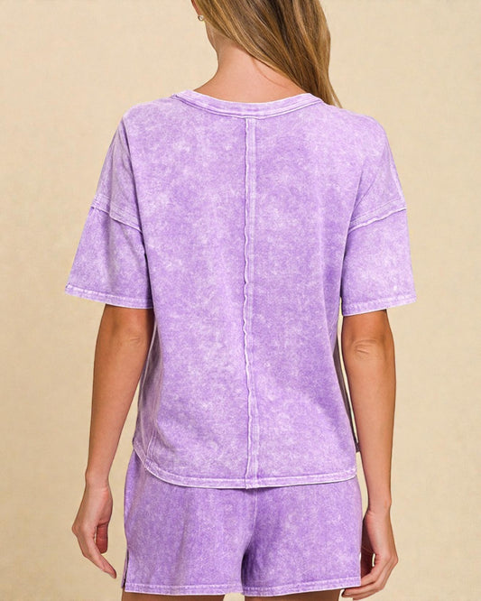 Person wearing a purple tie-dye outfit on a beige background