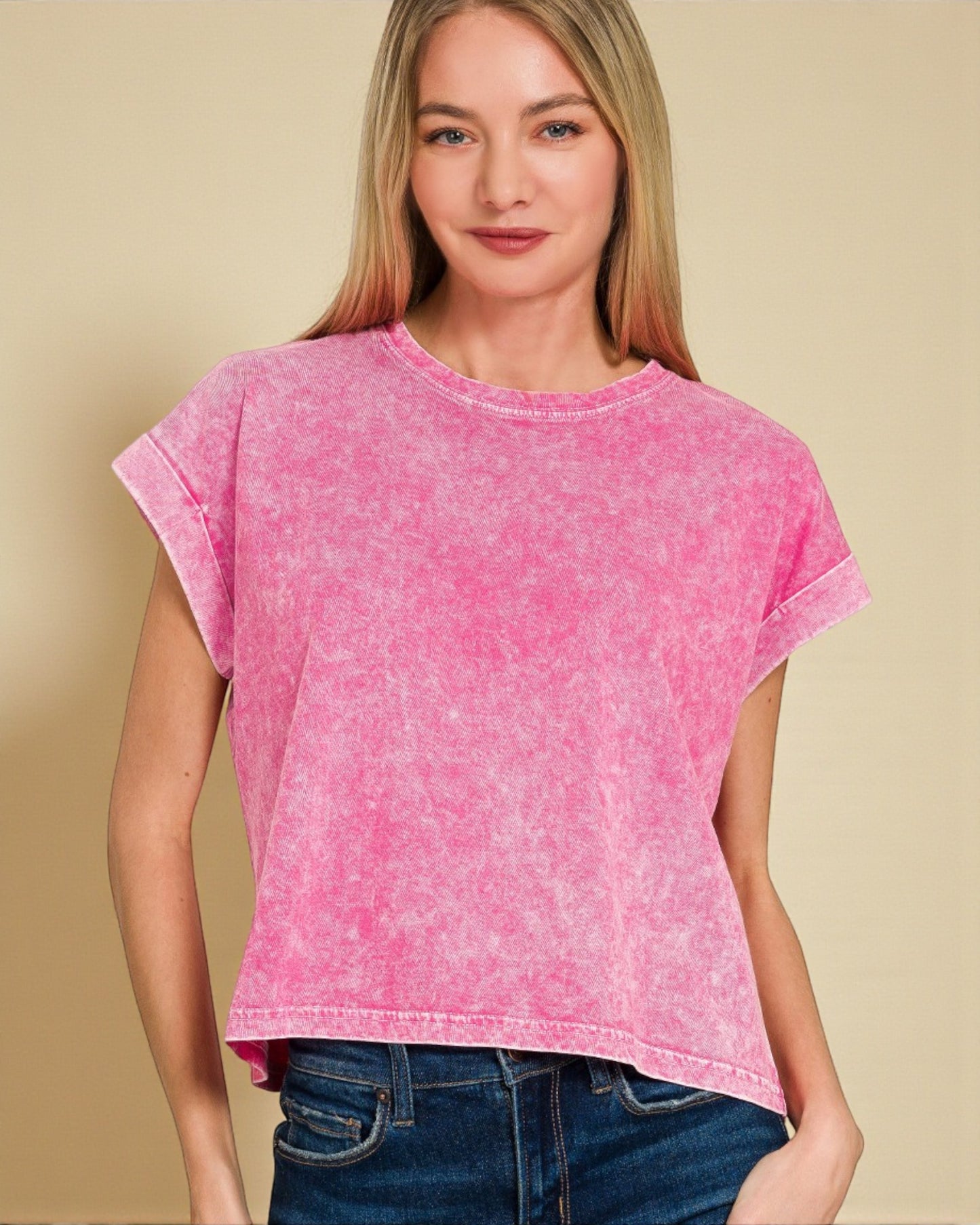 Woman wearing a pink t-shirt against a beige background