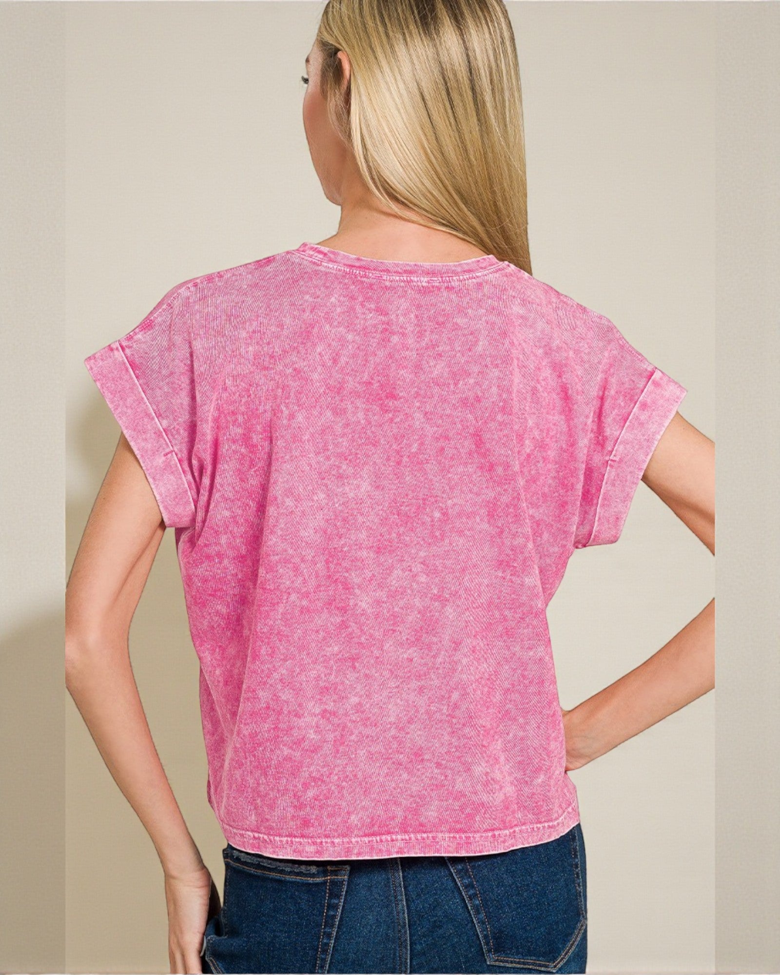 Person wearing a pink t-shirt with a plain background