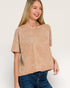 Woman wearing a beige marled top and blue jeans on a white background