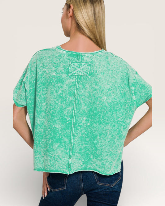 Woman wearing a green distressed shirt on a white background