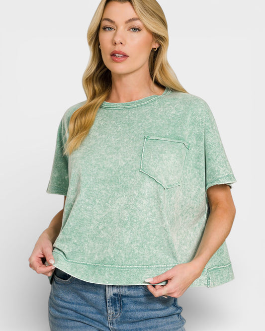 Woman wearing a green t-shirt with a pocket on a white background