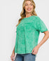 Woman wearing a green top with a plain background