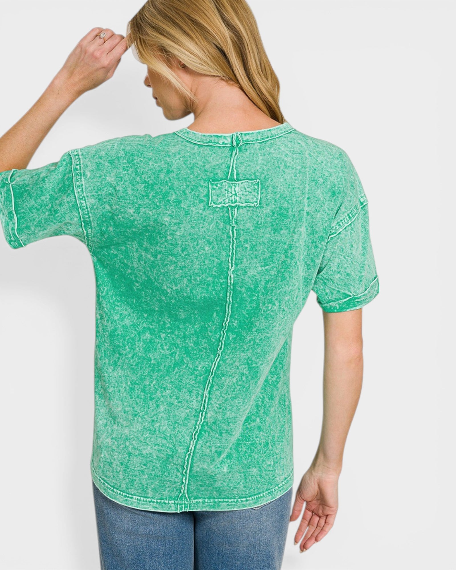 Person wearing a green acid-wash t-shirt on a white background
