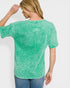 Person wearing a green acid-wash t-shirt on a white background