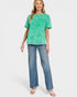 Woman wearing a green top and blue jeans on a white background