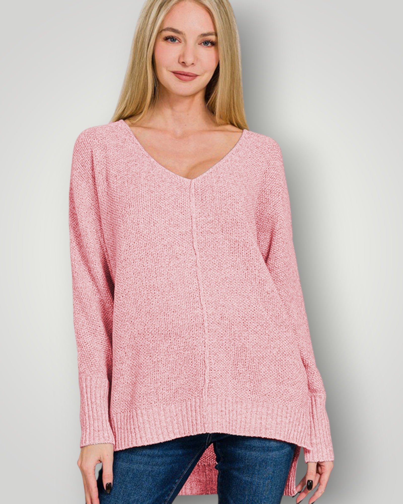 Woman wearing a pink sweater against a plain background