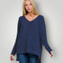 Woman wearing a blue sweater against a plain background
