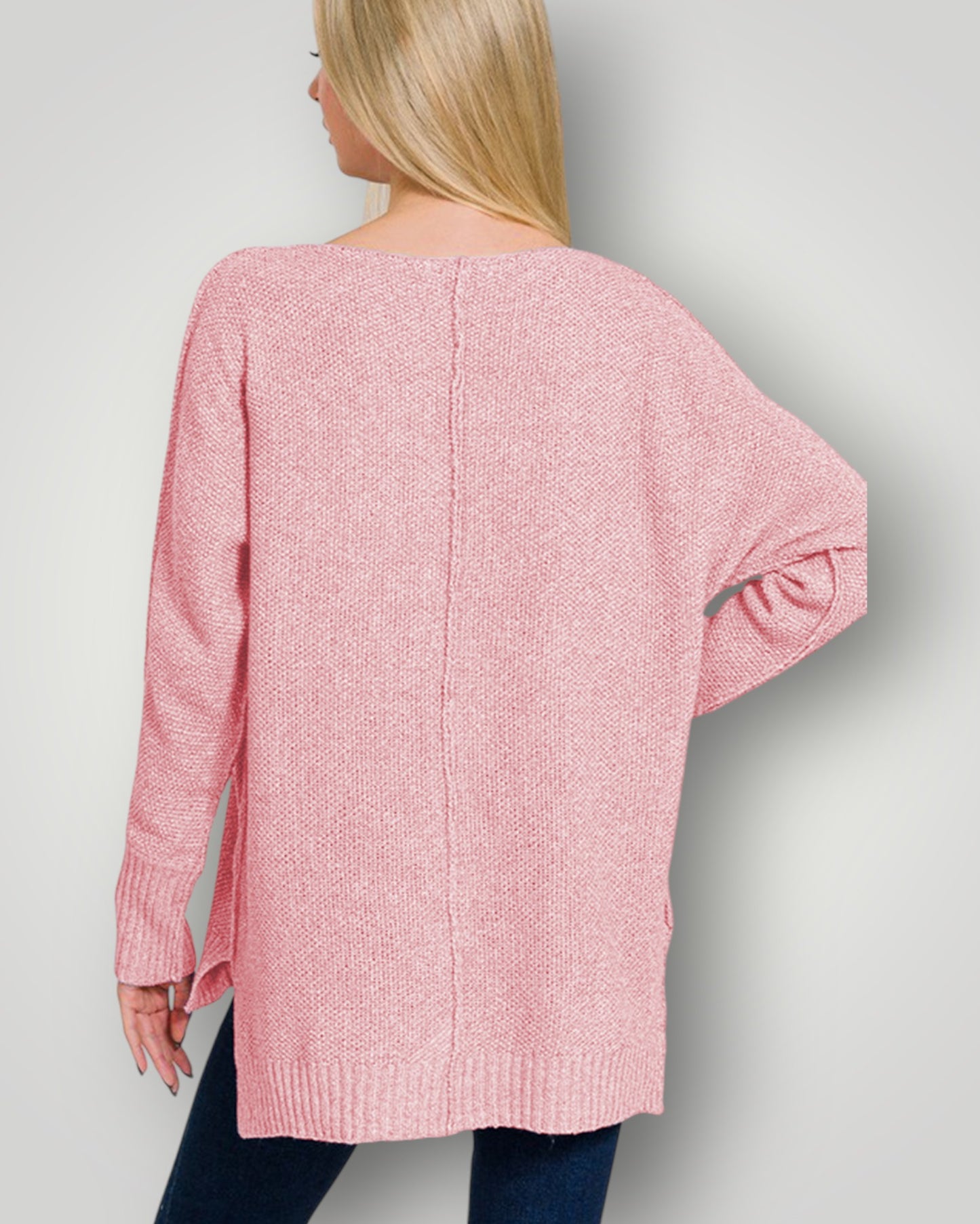 Person wearing a pink sweater against a plain background