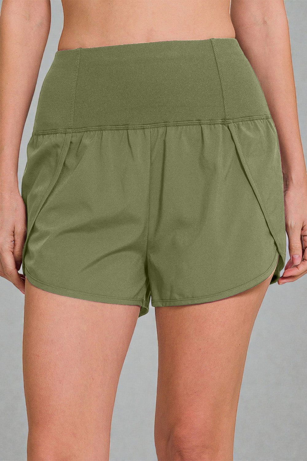 Green shorts worn by a person on a gray background
