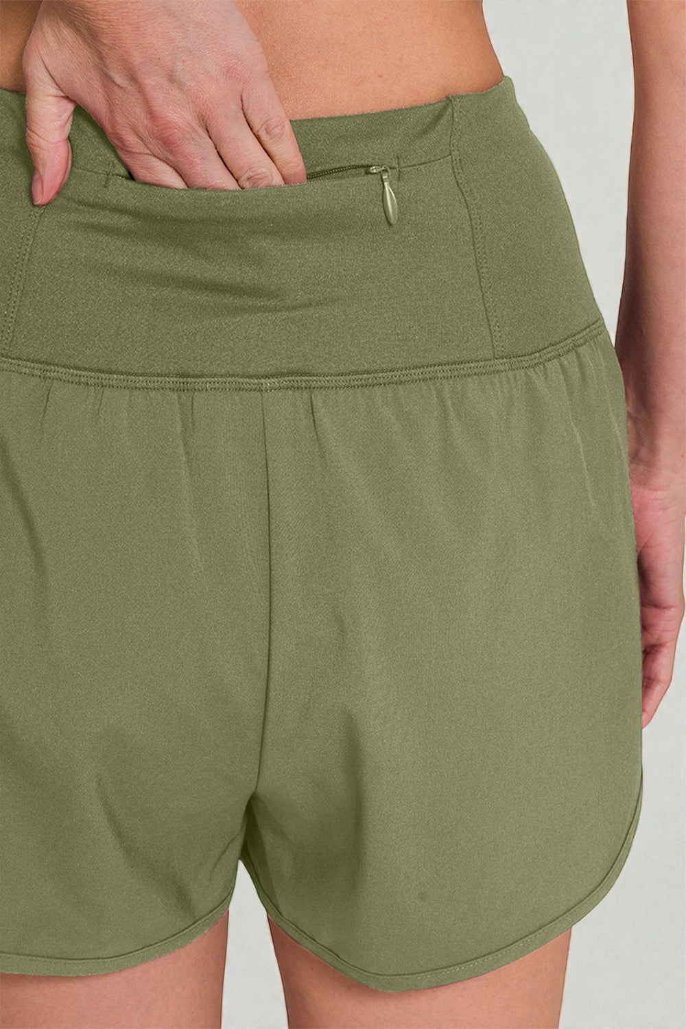 Green shorts worn by a person on a plain background