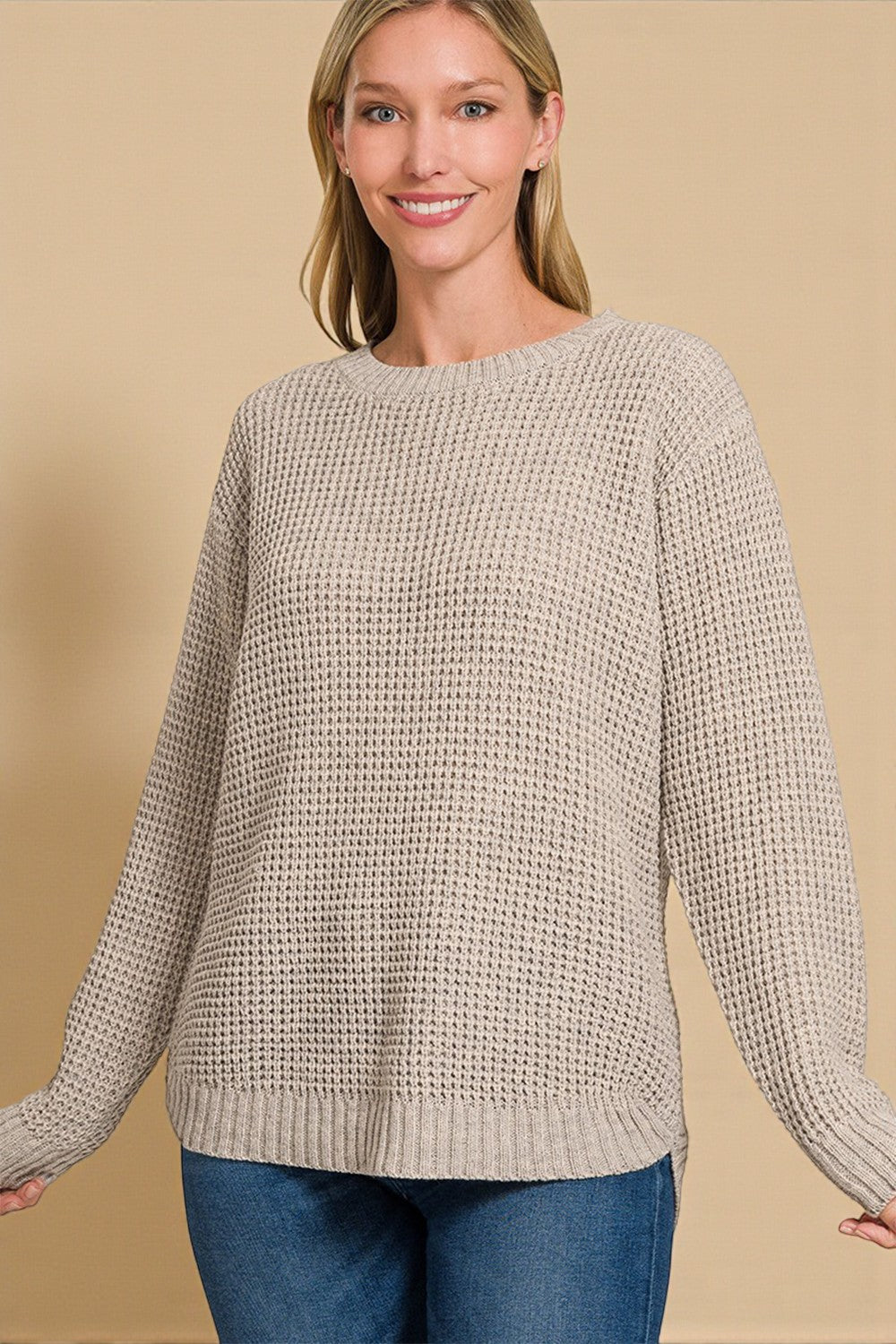 Woman wearing a beige knitted sweater against a beige background