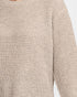 Close-up of a beige textured knit sweater with a ribbed crew neck and long sleeve, showing the detailed waffle-knit pattern.