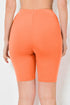 Orange bike shorts worn by a person on a white background