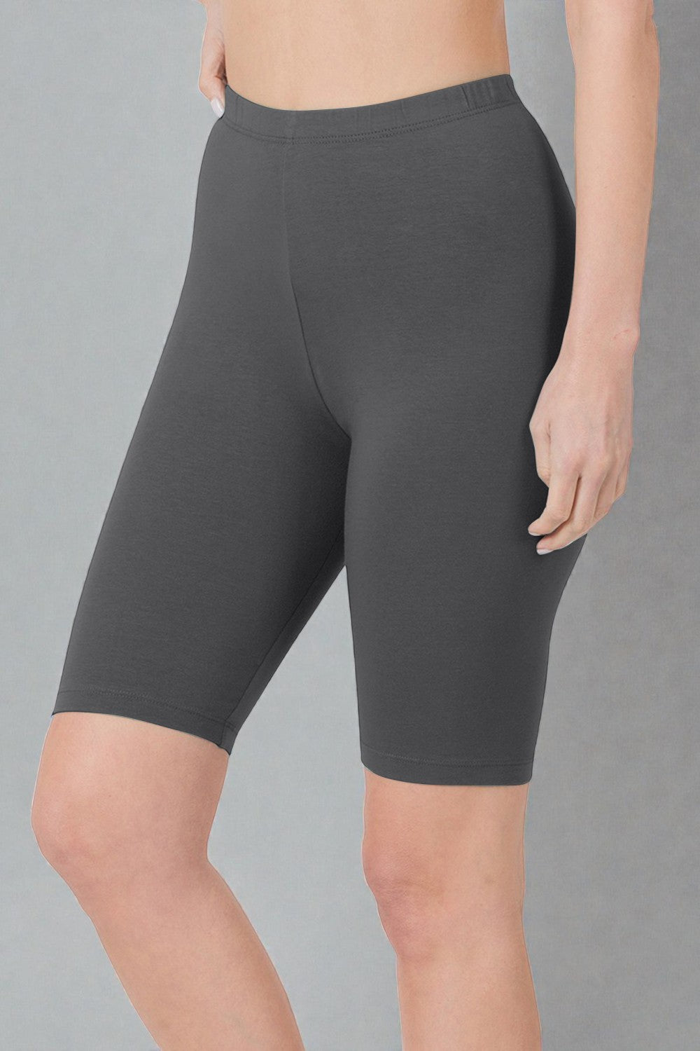 Person wearing dark gray shorts on a gray background