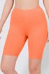 Orange athletic shorts worn by a person on a white background