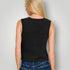 Person wearing a black sleeveless top and blue jeans against a plain background