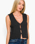 A blonde woman wearing a dark charcoal gray knit sleeveless vest with a deep V-neck and front keyhole cutout, paired with blue jeans, against a plain white studio background.