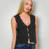 Woman wearing a black sleeveless knitted top against a plain background