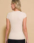 Woman wearing a beige t-shirt against a beige background