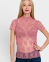 Woman wearing a pink lace top against a plain background