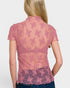 Pink lace top worn by a person on a white background