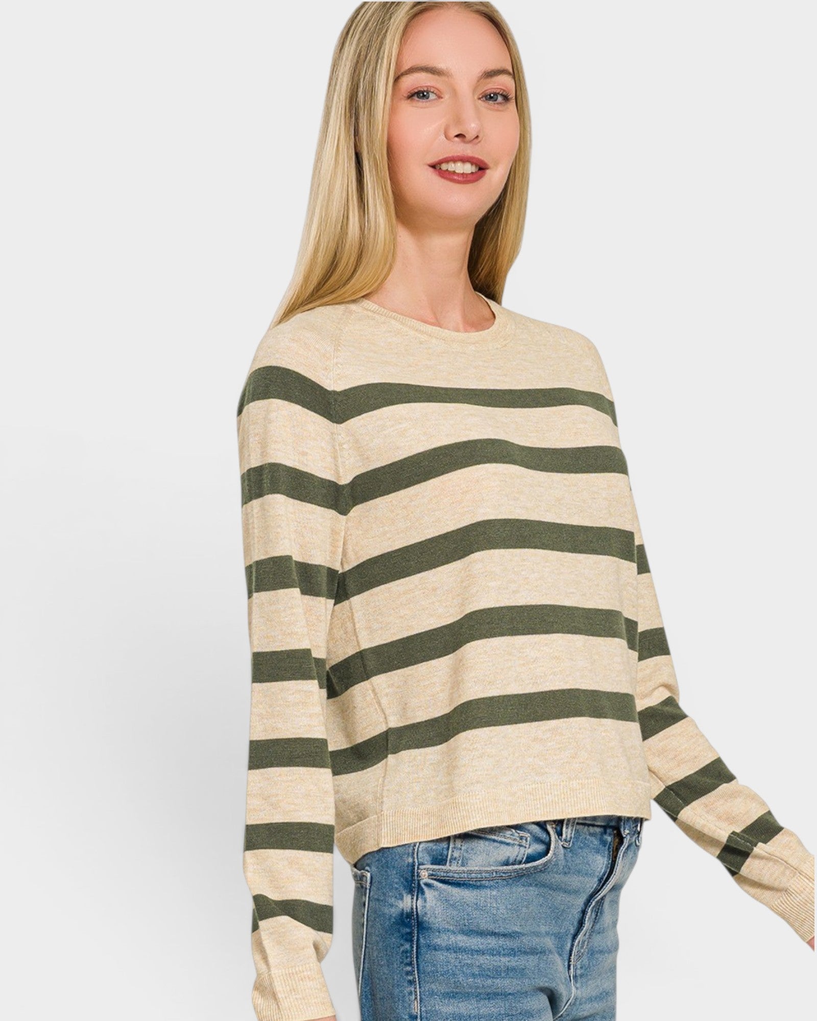 Woman wearing a beige and green striped sweater on a white background